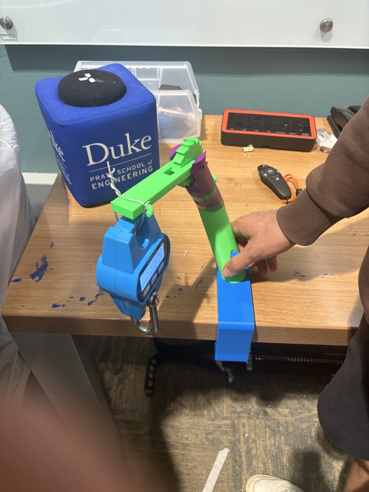 Load testing the printed joint arm with a hanging scale. It gave out at 22.95 lb.